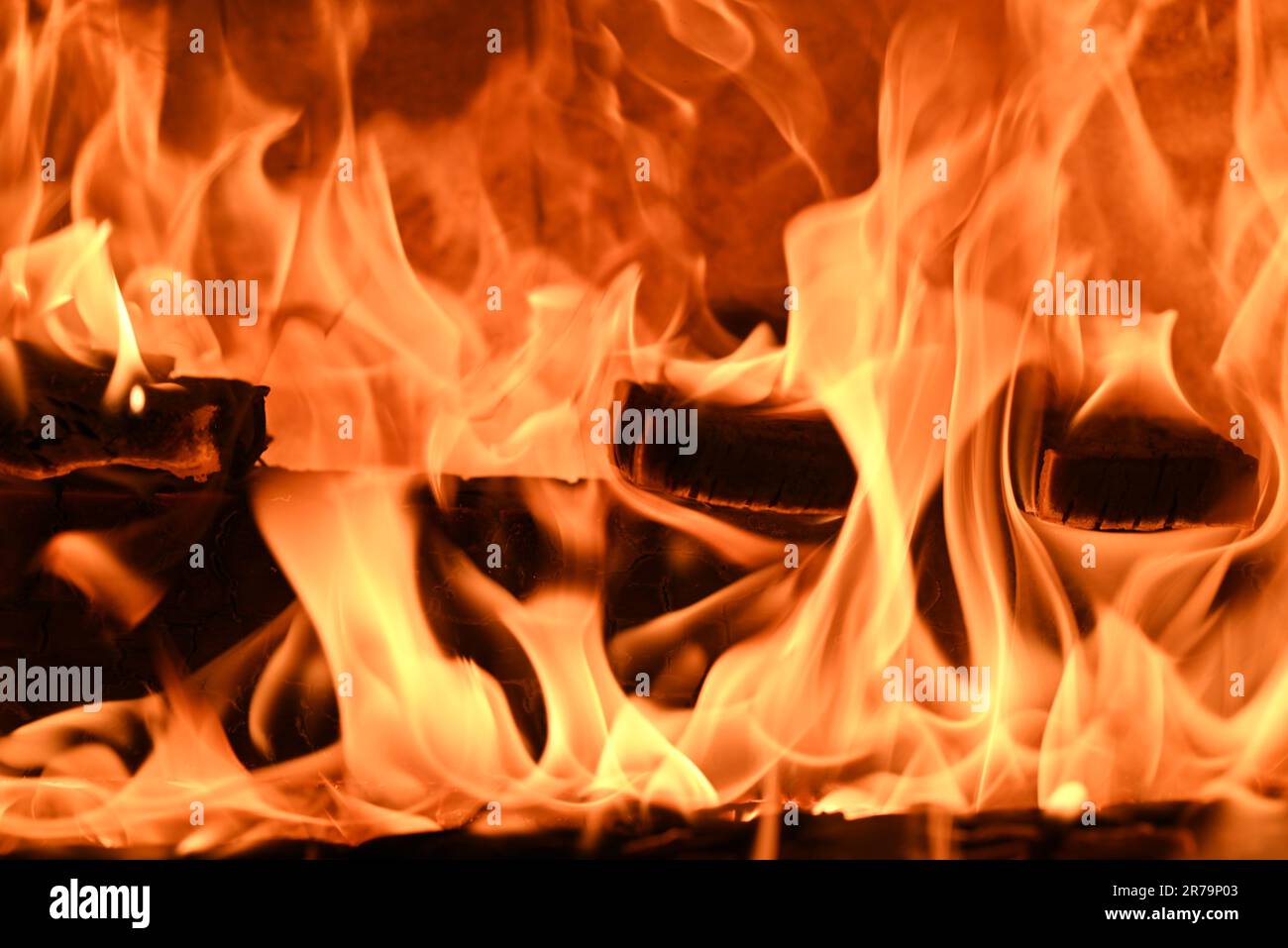 A cozy fireplace with a crackling fire blazing away in the center Stock Photo