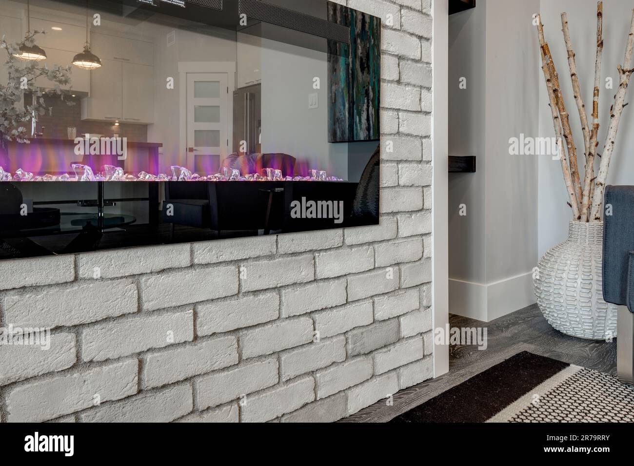 A modern interior design with an electronic fireplace in a white brick wall Stock Photo