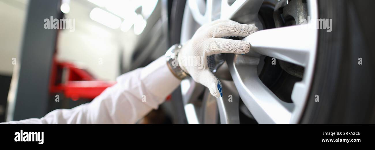 Mechanic changes car wheel in auto repair shop Stock Photo - Alamy