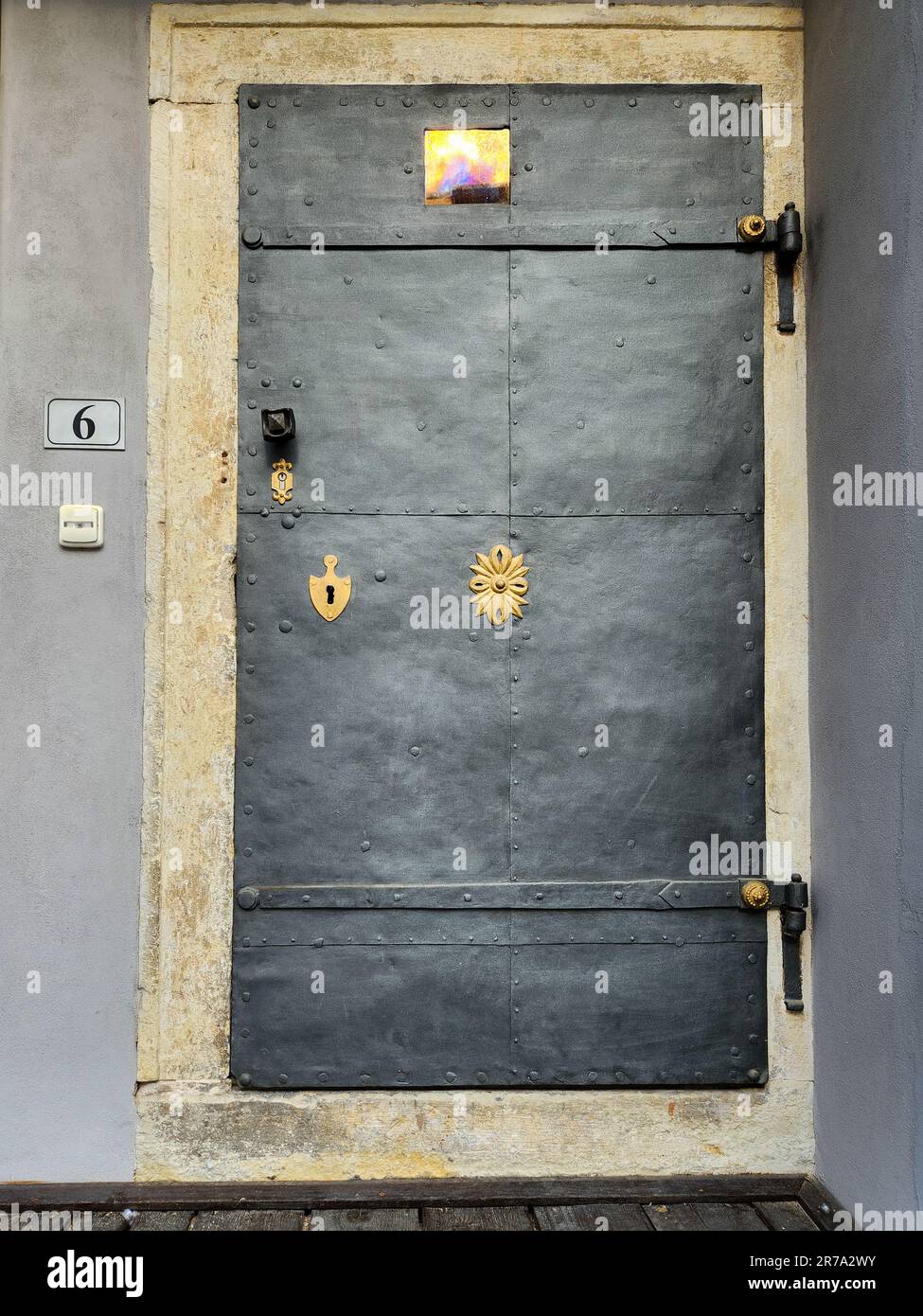 rustic black metal door with golden hardware exterior entrance Stock Photo