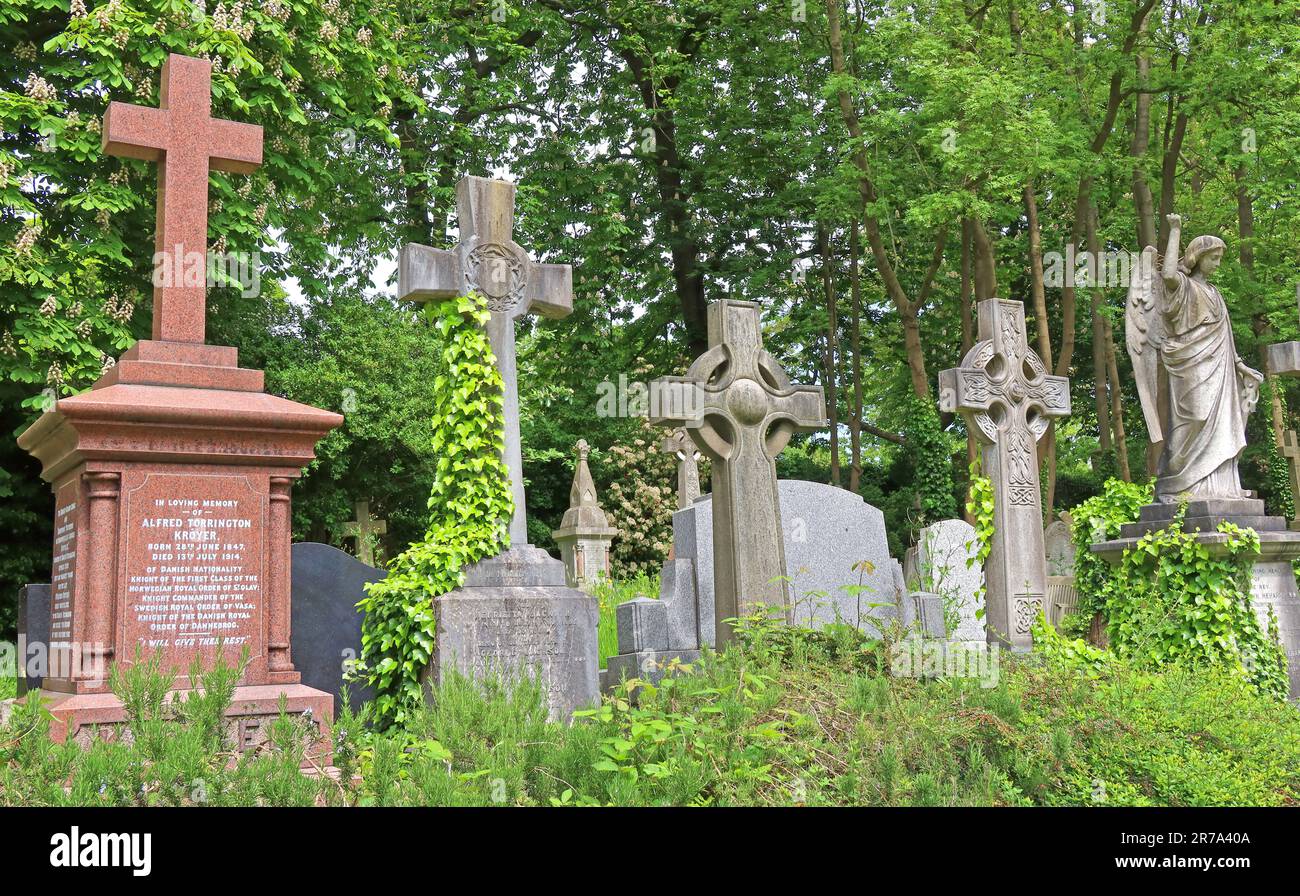 Stone crosses and grave monuments among dense greenery in Highgate Cemetery, a historic Victorian burial ground in North London, England, UK. Stock Photo