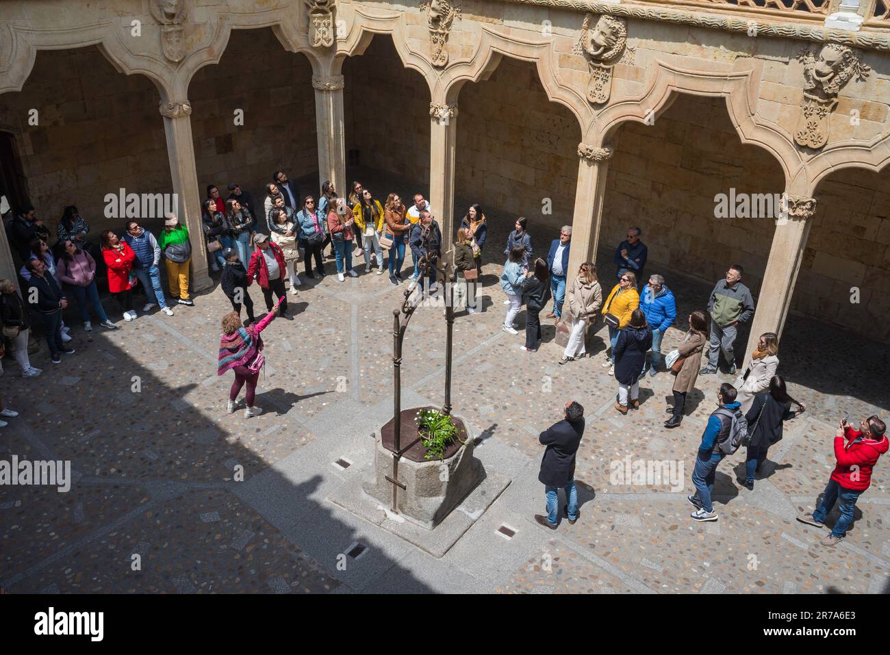 Tour group Europe, view in summer of tourists listening to their tour guide in the patio courtyard of the Casa de las Conchas in Salamanca, Spain Stock Photo