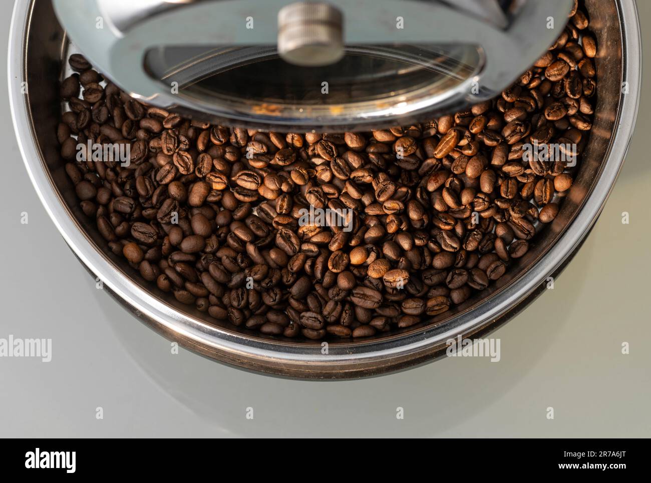 Freshly roasted coffee beans in the cooling tray of a countertop home coffee roaster. Stock Photo