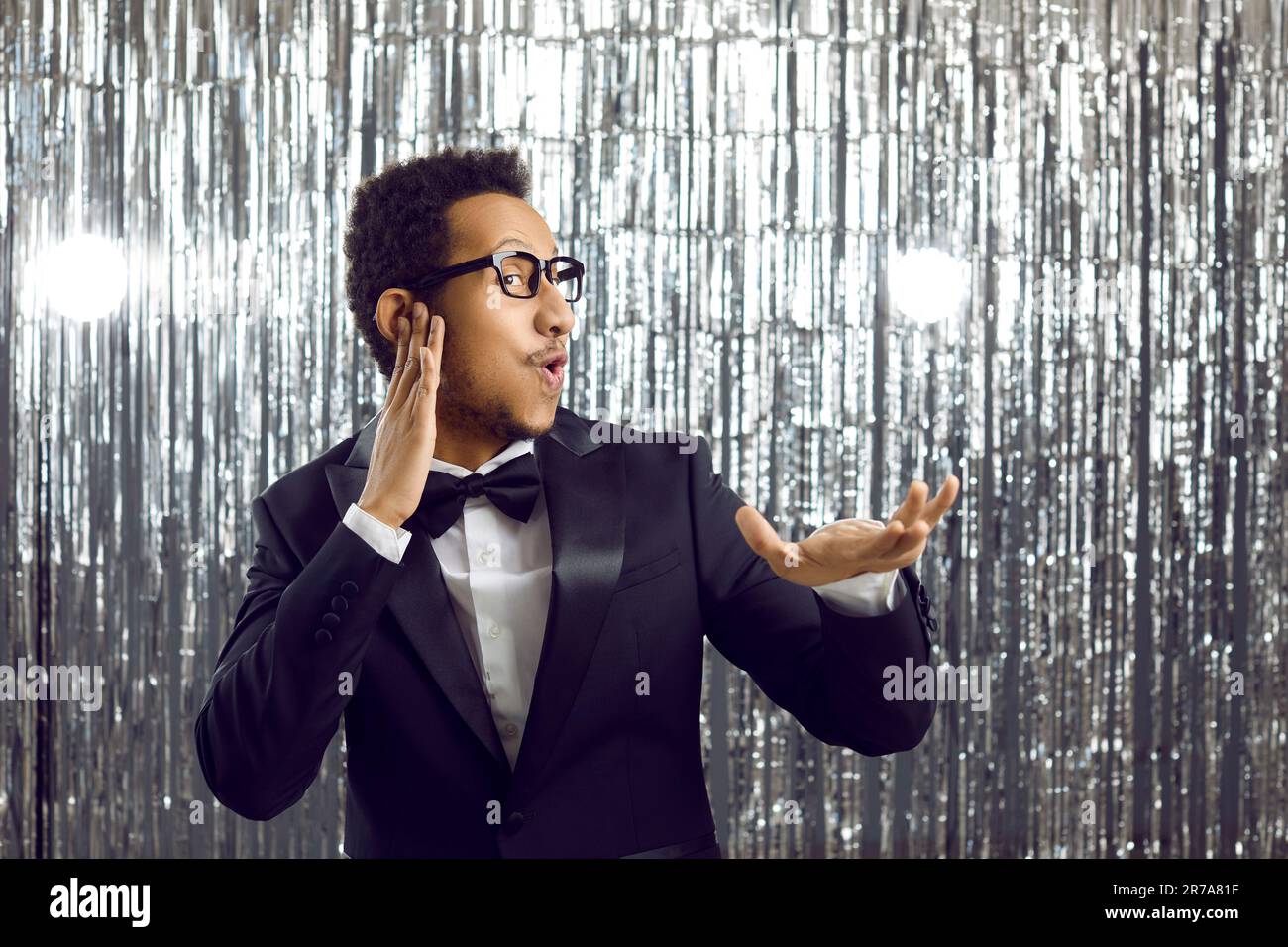 Funny cheerful black guy in suit dancing at disco party like DJ who's mixing music Stock Photo