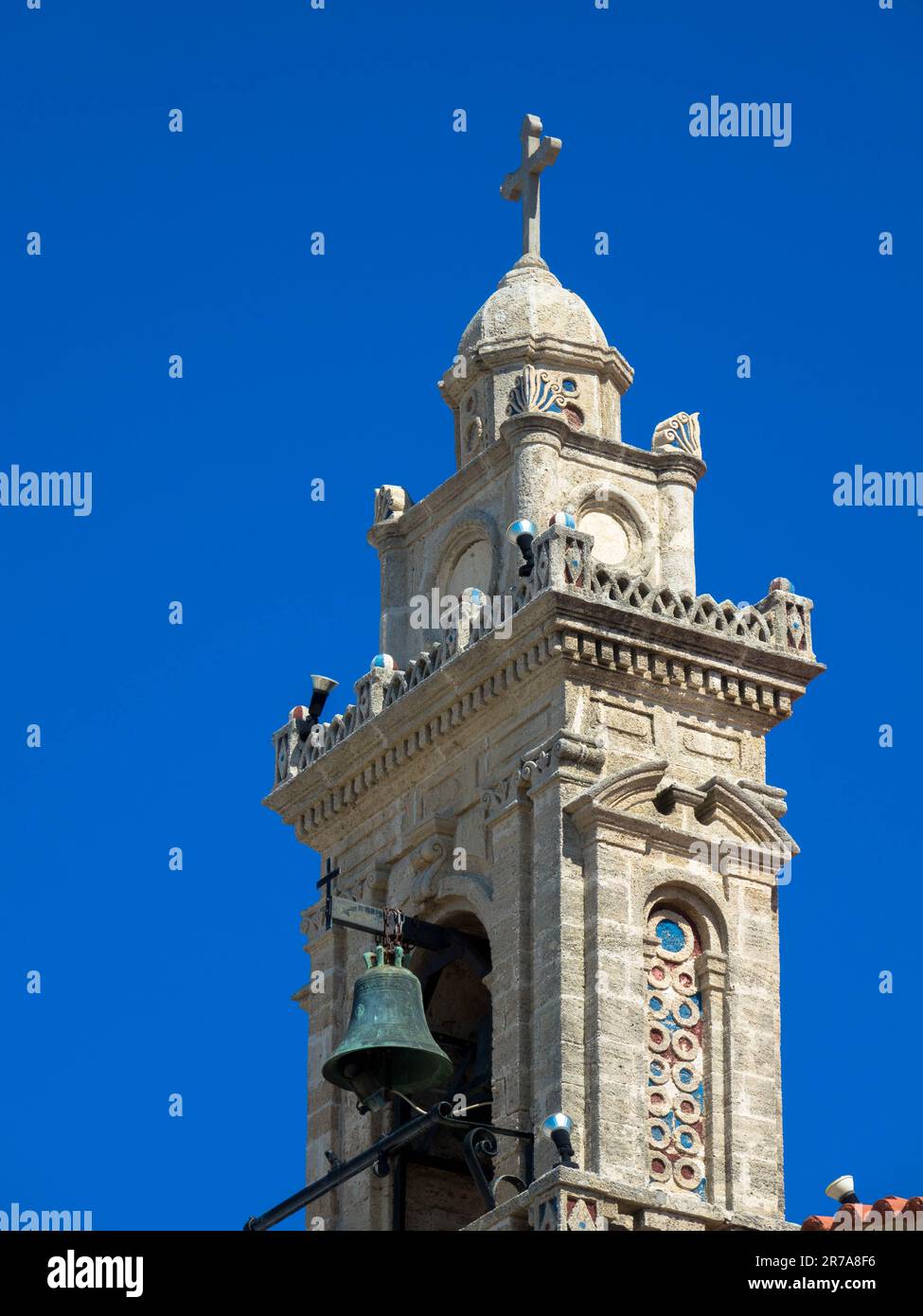 Church tower with bell against blue sky. Fanes, Rhodes island, Greece. Close up. Stock Photo