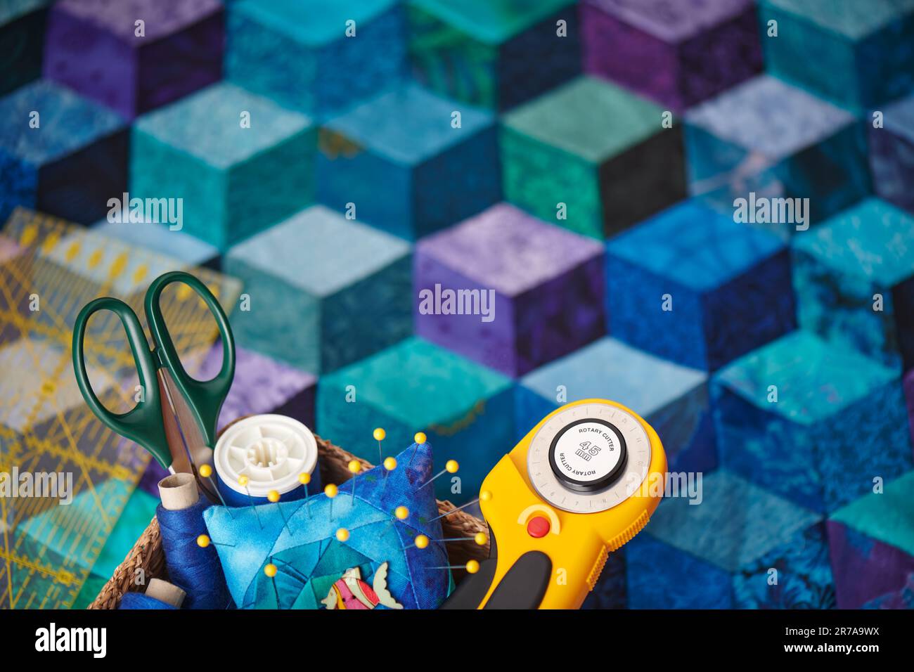 Quilting accessories on the background of a tumbling blocks quilt Stock Photo