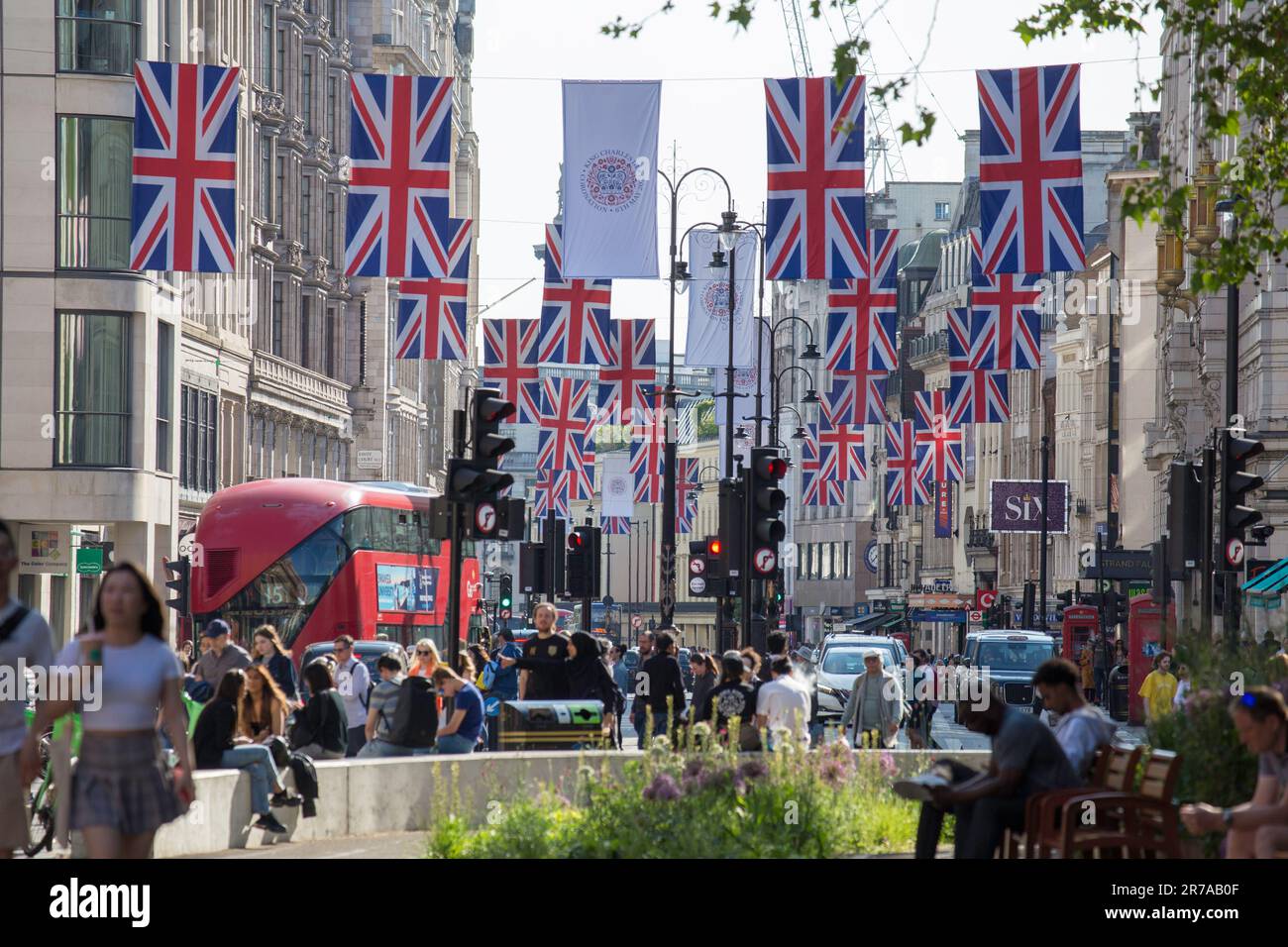 Union Jack Flags on The Strand London with a red bus Stock Photo