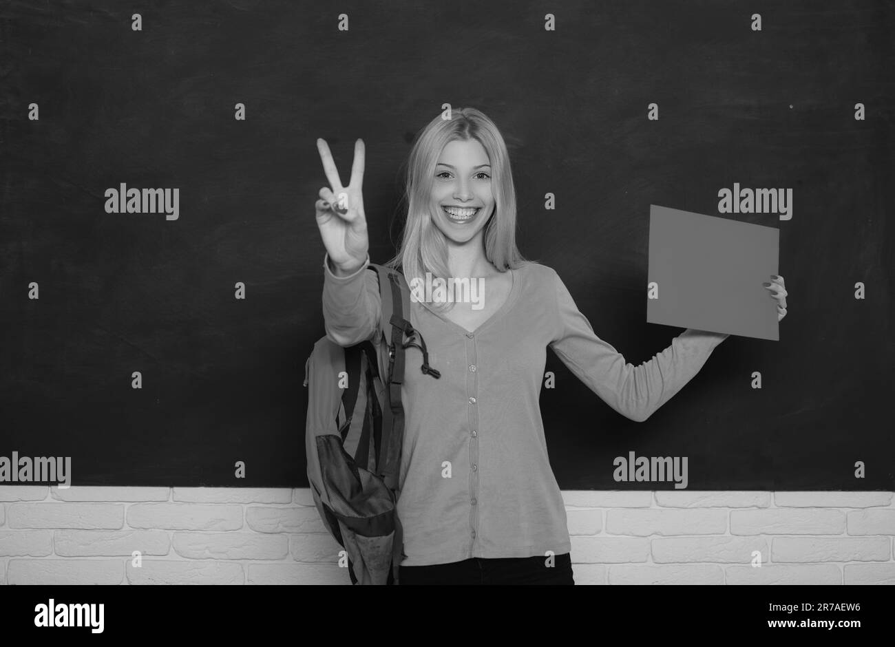 Female teacher in the classroom on the chalkboard. College girl in