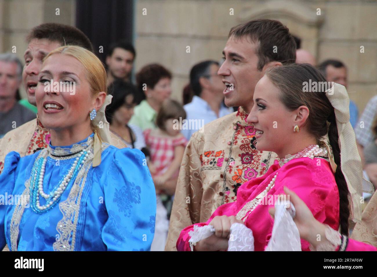 A diverse group of people in vibrant clothing are enjoying a lively ...