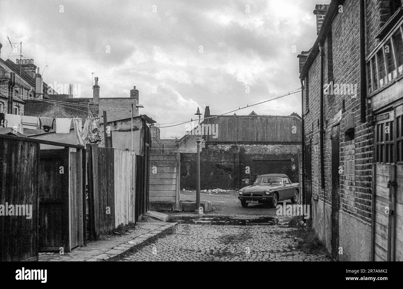 1976 archive image of new MG sports car parked by cobbled back alley at Percy Road, Finchley in North London. Stock Photo