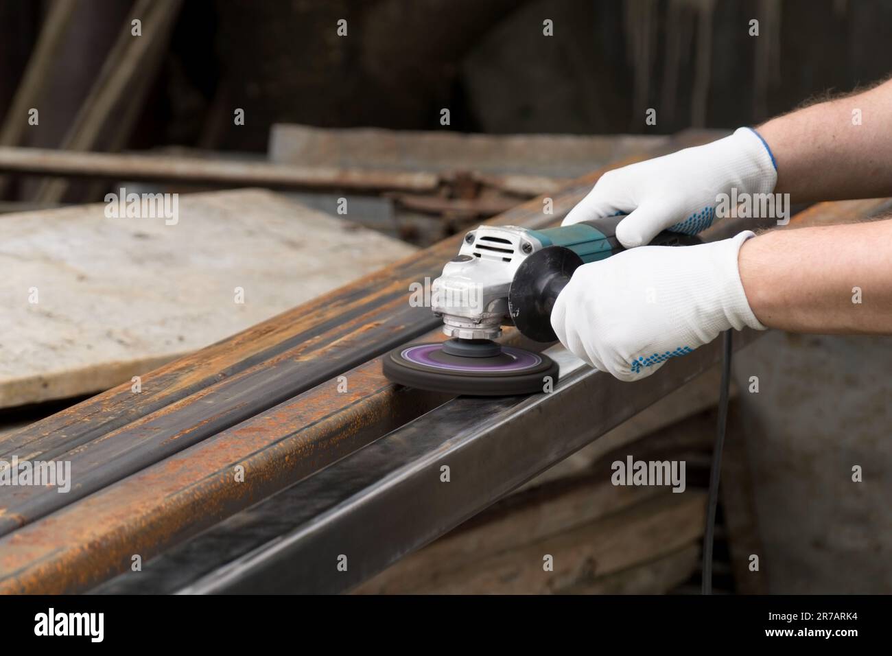 A man working with electric angle grinder tool. Removing rust a metal