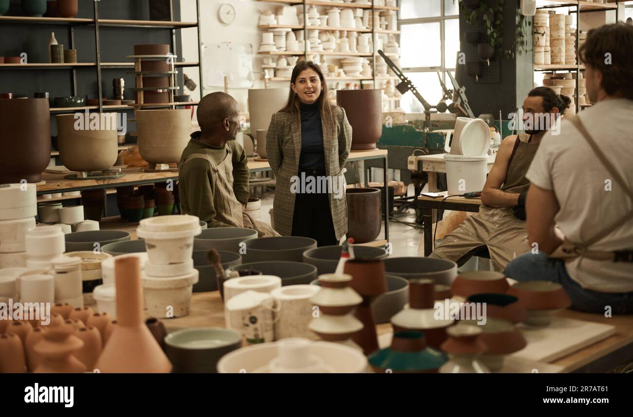 Smiling manager talking with workers in a ceramics studio Stock Photo