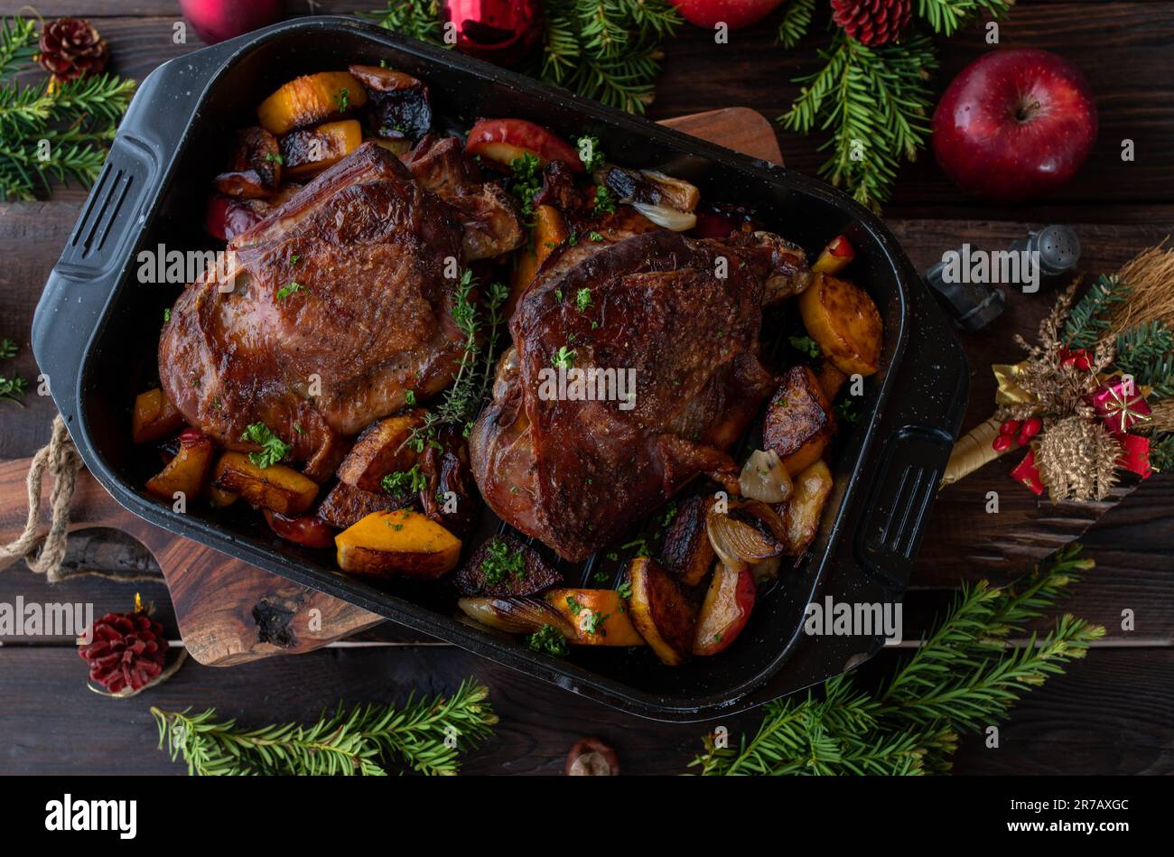 Christmas meat dish with roasted turkey shank and vegetables on wooden table Stock Photo