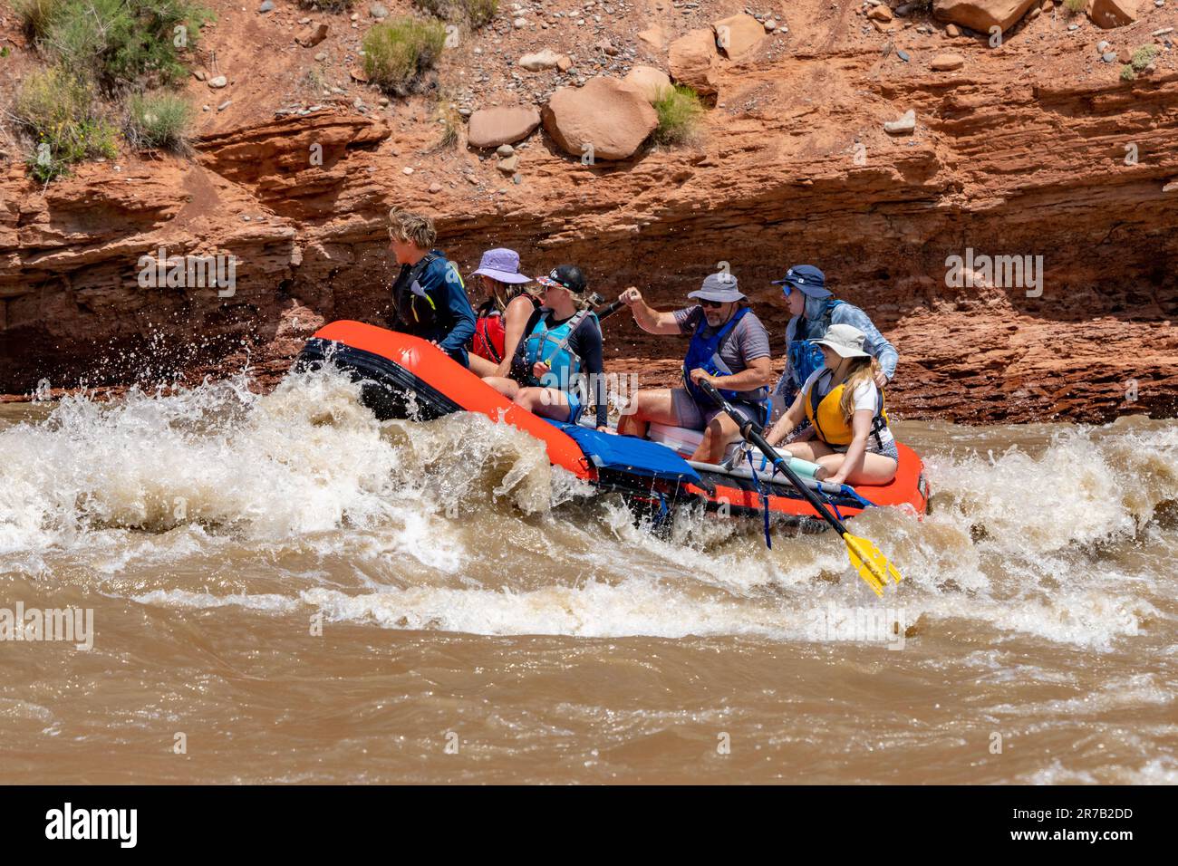 A family rafting trip through the big waves in White's Rapid on the Colorado River at high water.  Moab, Utah. Stock Photo