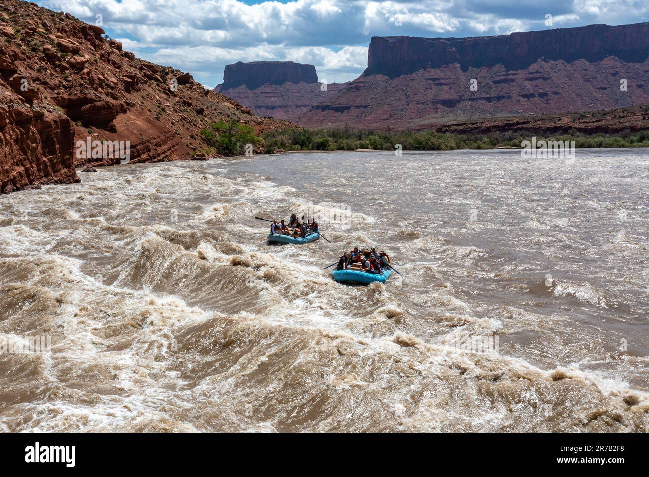Tourists enjoy a rafting trip through the big waves in White's Rapid on the Colorado River at high water.  Moab, Utah. Stock Photo