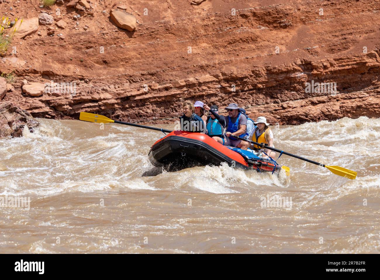A family rafting trip through the big waves in White's Rapid on the Colorado River at high water.  Moab, Utah. Stock Photo