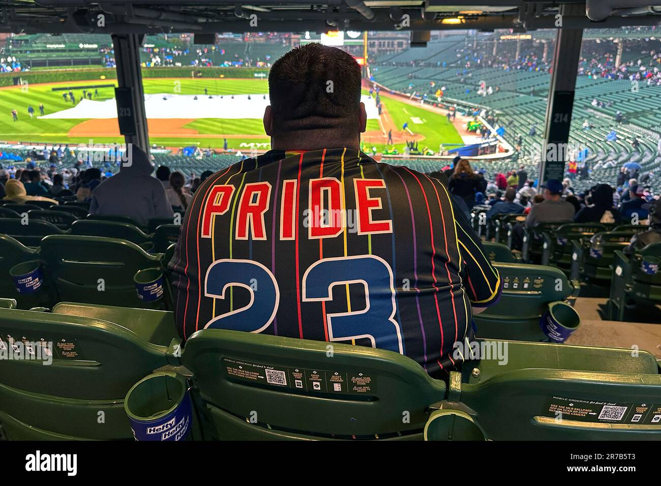 A baseball fan wears a Pride 23 Chicago Cubs jersey at Pride Night before a  baseball game between the Cubs and the Pittsburgh Pirates on Tuesday, June  13, 2023, in Chicago. (AP