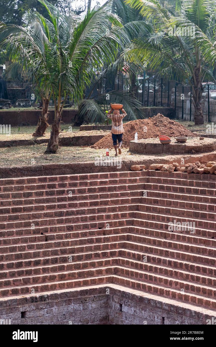 Old Goa, India - January 2023: A labourer working on the restoration of an old step well at the UNESCO heritage site of Old Goa. Stock Photo