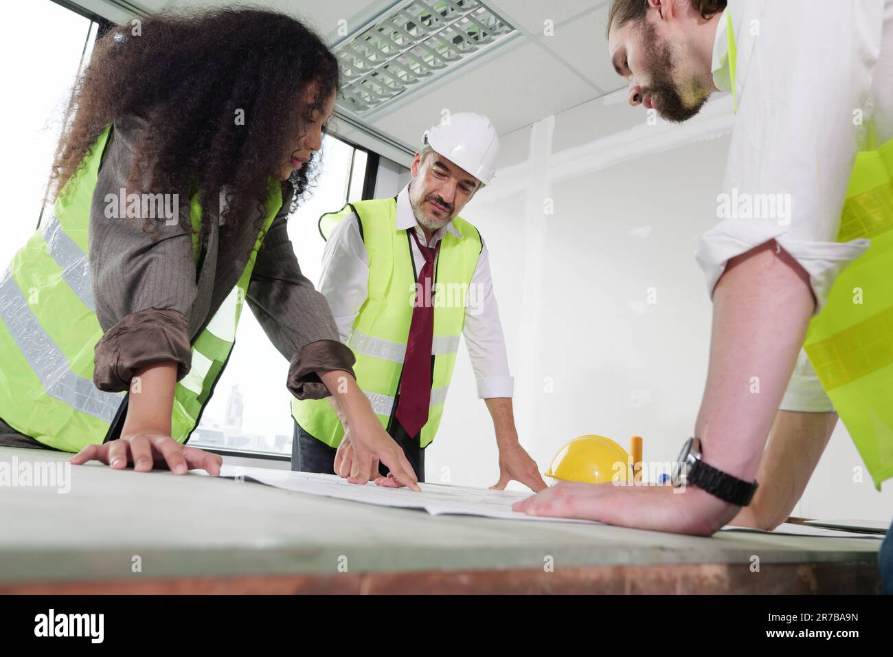 Construction engineers team using blueprint of project plan Stock Photo