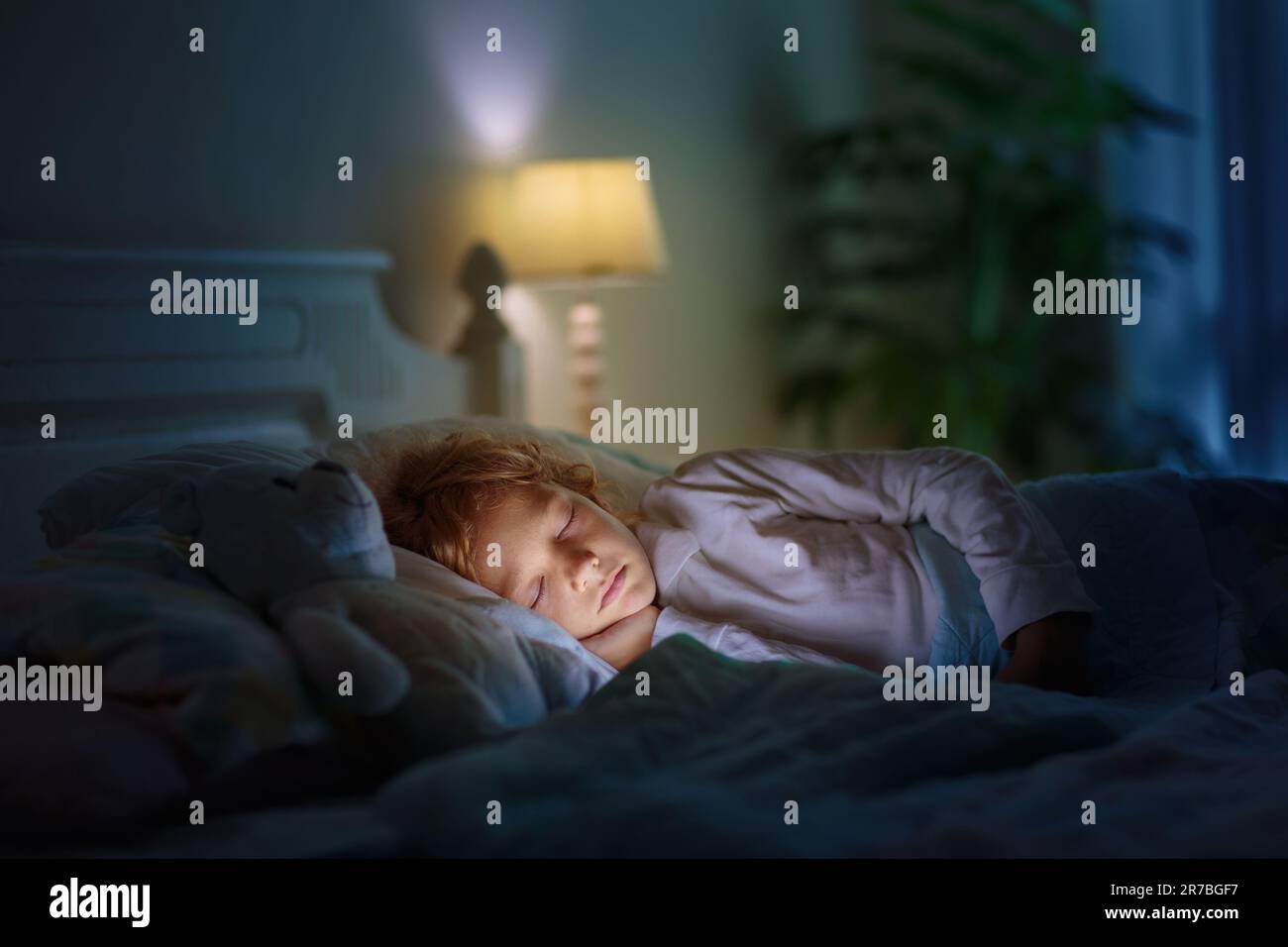 Child sleeping in dark bedroom. Little boy napping. Healthy night rest