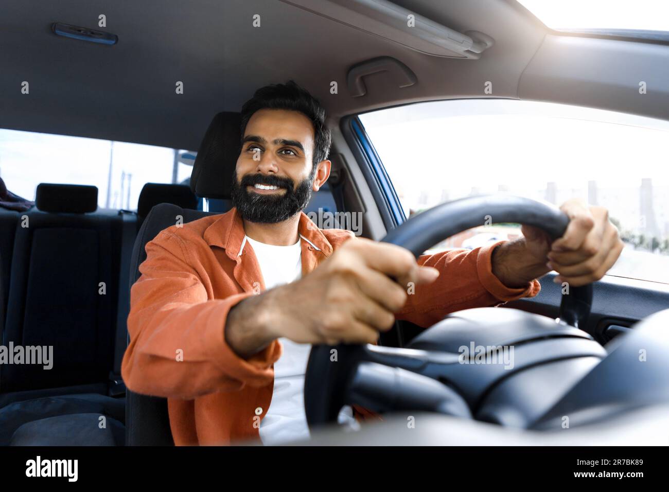 Smiling Bearded Indian Man Driving Auto Sitting In Driver's Seat Stock Photo