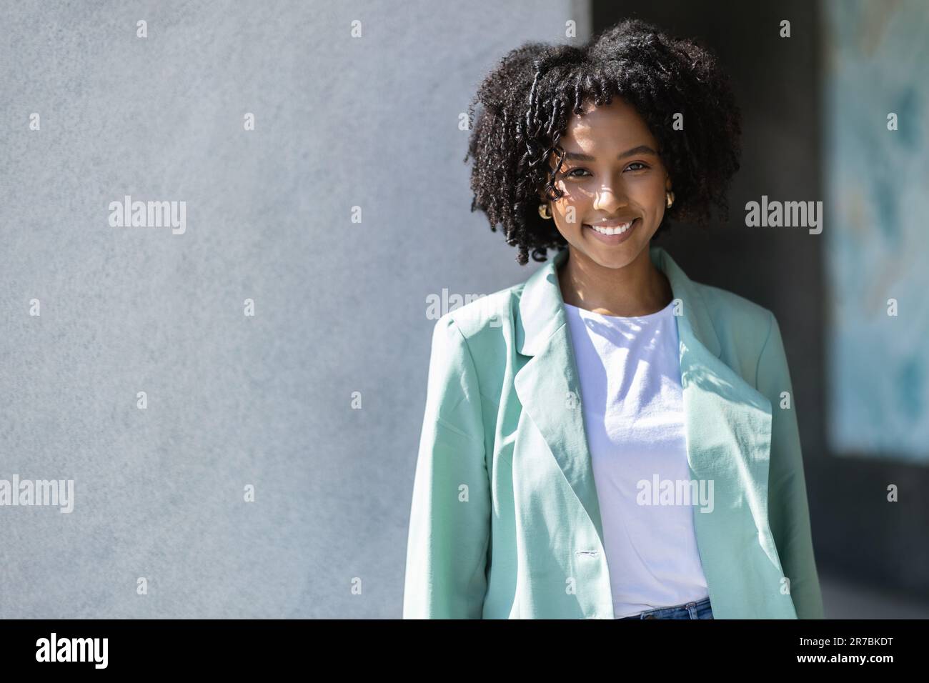 Happy pretty young black woman employee posing outdoor Stock Photo - Alamy