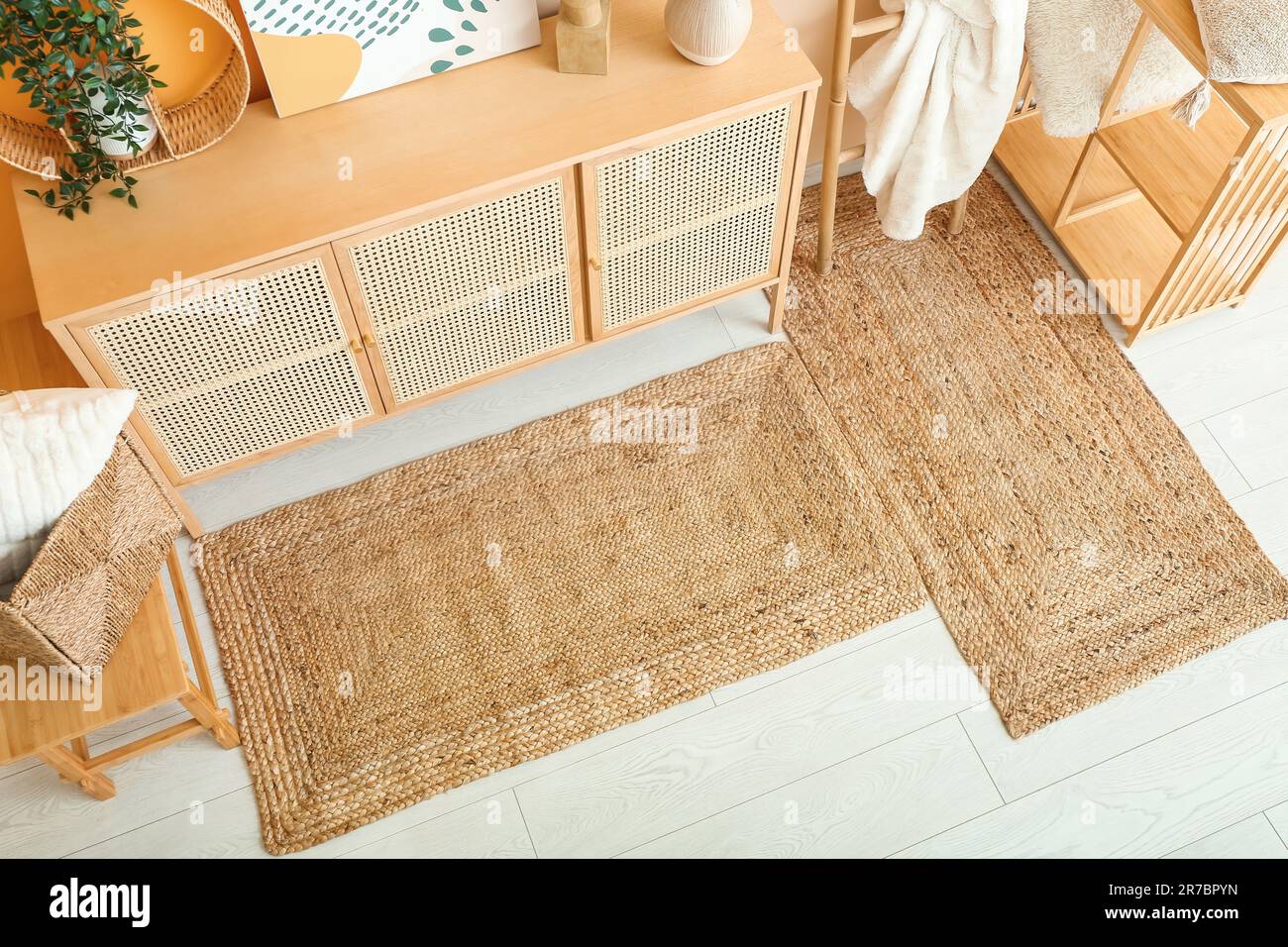 Stylish interior of living room with drawers, shelving unit and wicker ...