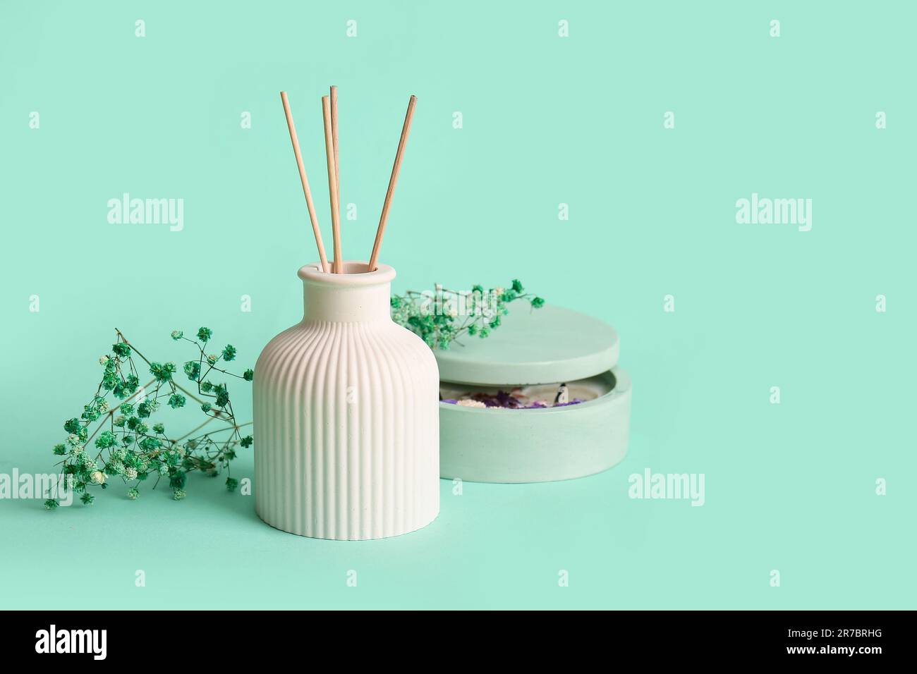 Floral reed diffuser and gypsophila flowers on turquoise background ...