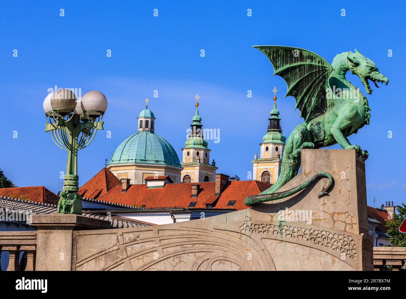 the green statue of the dragon bridge of ljubljana and the green domes of st nicholas cathedral Stock Photo