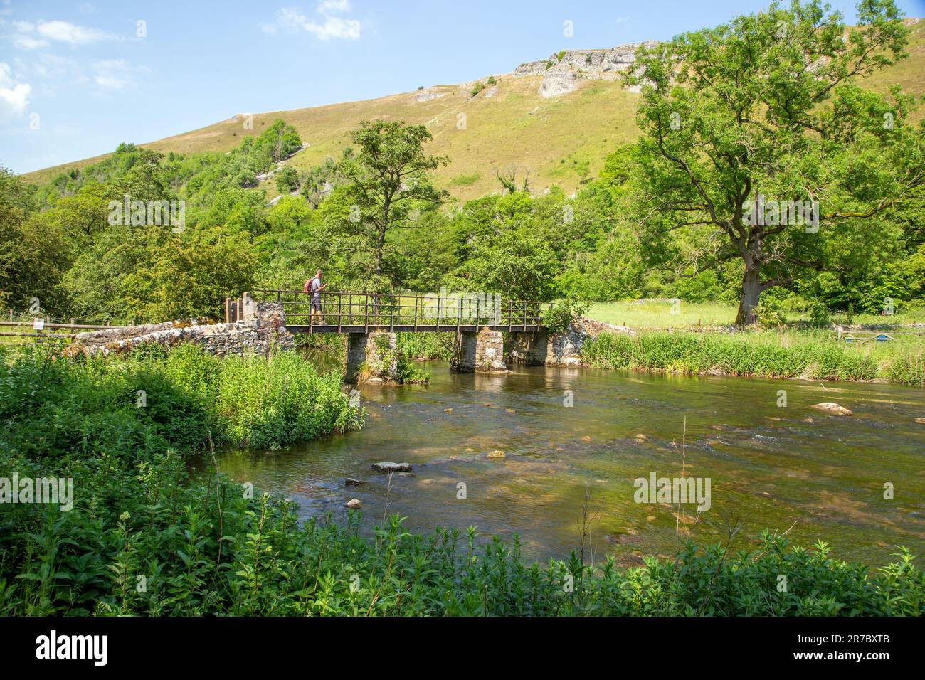 Footbridge over the river Wye in the Derbyshire Peak District beauty spot of Monsall Dale below