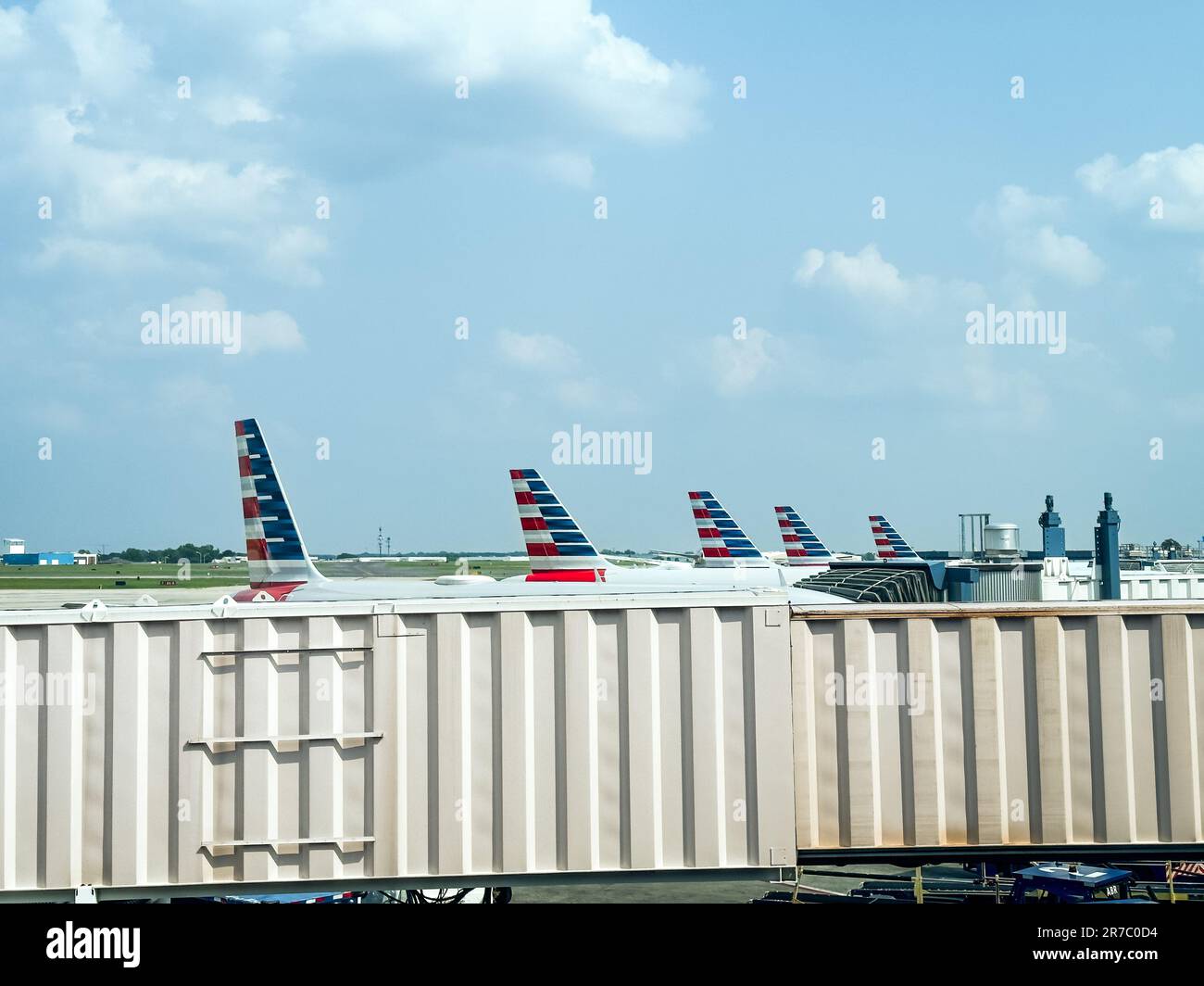 American Airlines airplane tails beyond a jet bridge at Denver International Airport in Colorado. Stock Photo