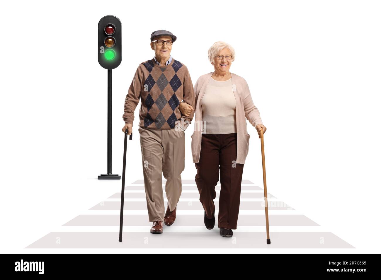 Full length portrait of an elderly man and woman walking with canes at pedestrian crossing isolated on white background Stock Photo