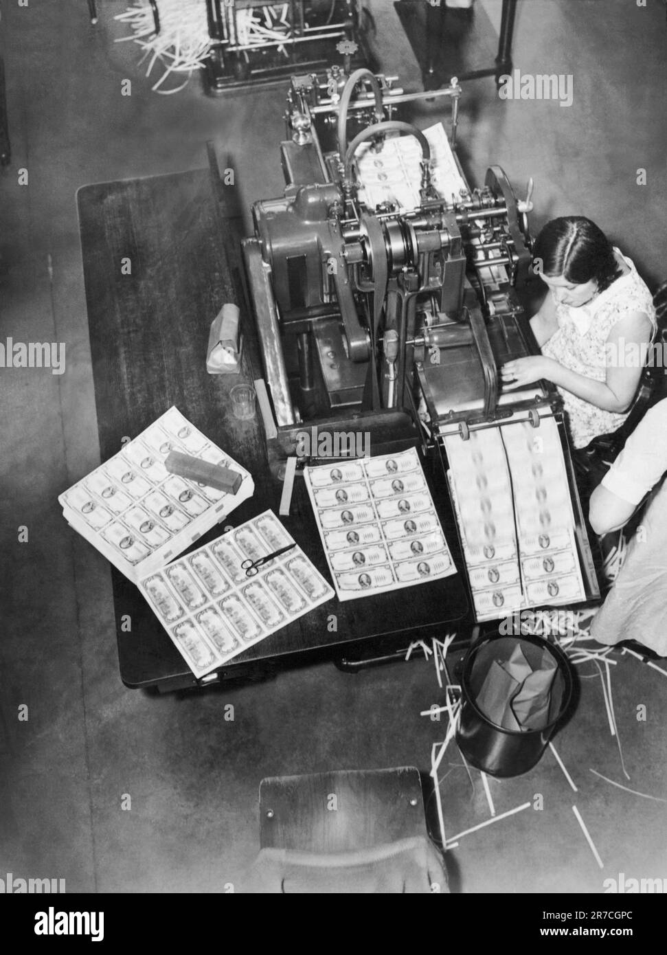 Washington, D.C.:  c. 1929 Workers at the Bureau of Engraving trimming the edges of sheets of hundred dollar bills. Stock Photo