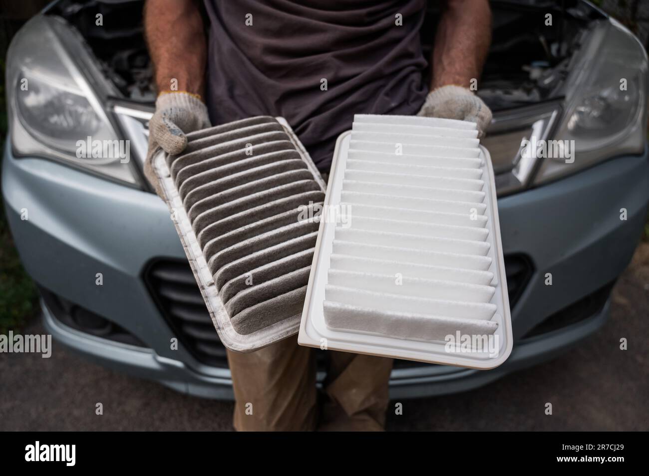 The master changes the air filter in the car engine Stock Photo Alamy