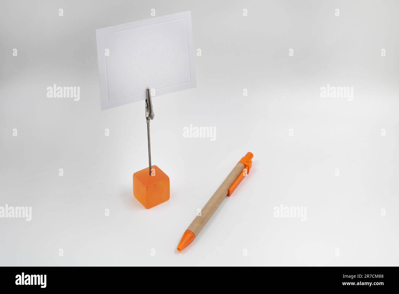 A small orange paper-holder sitting next to an orange and brown pen, with copy space Stock Photo