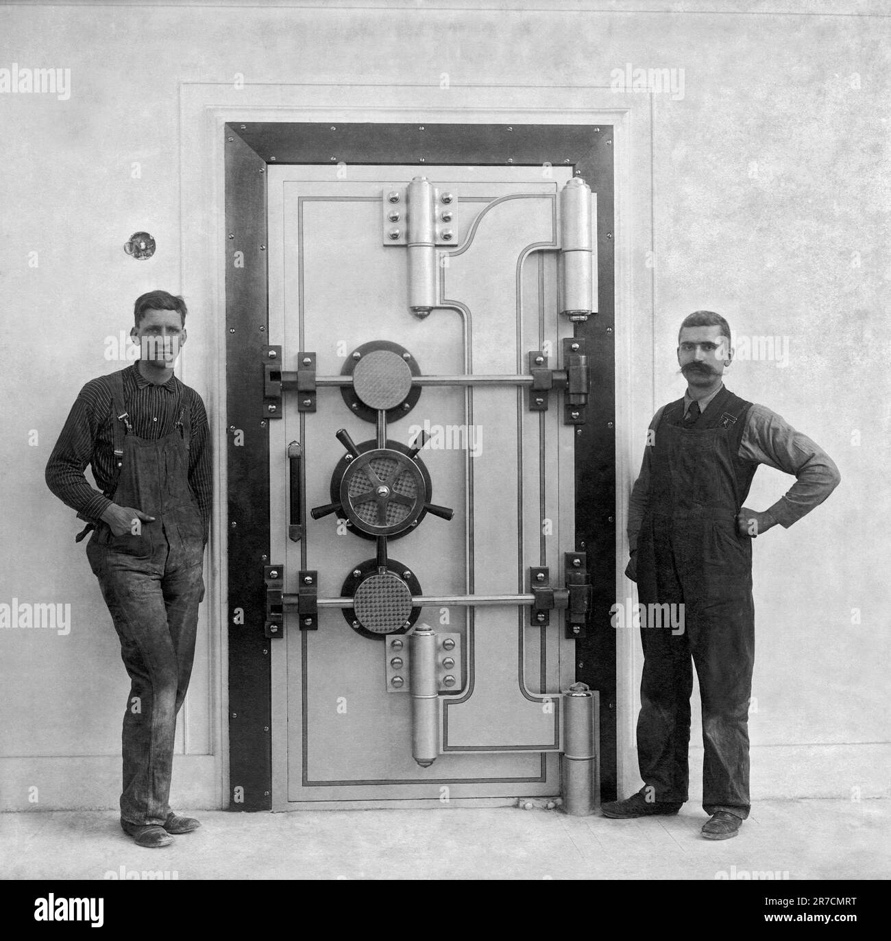 San Francisco, California:  July 6, 1909. Two workmen stand by a recently completed bank vault door. Stock Photo