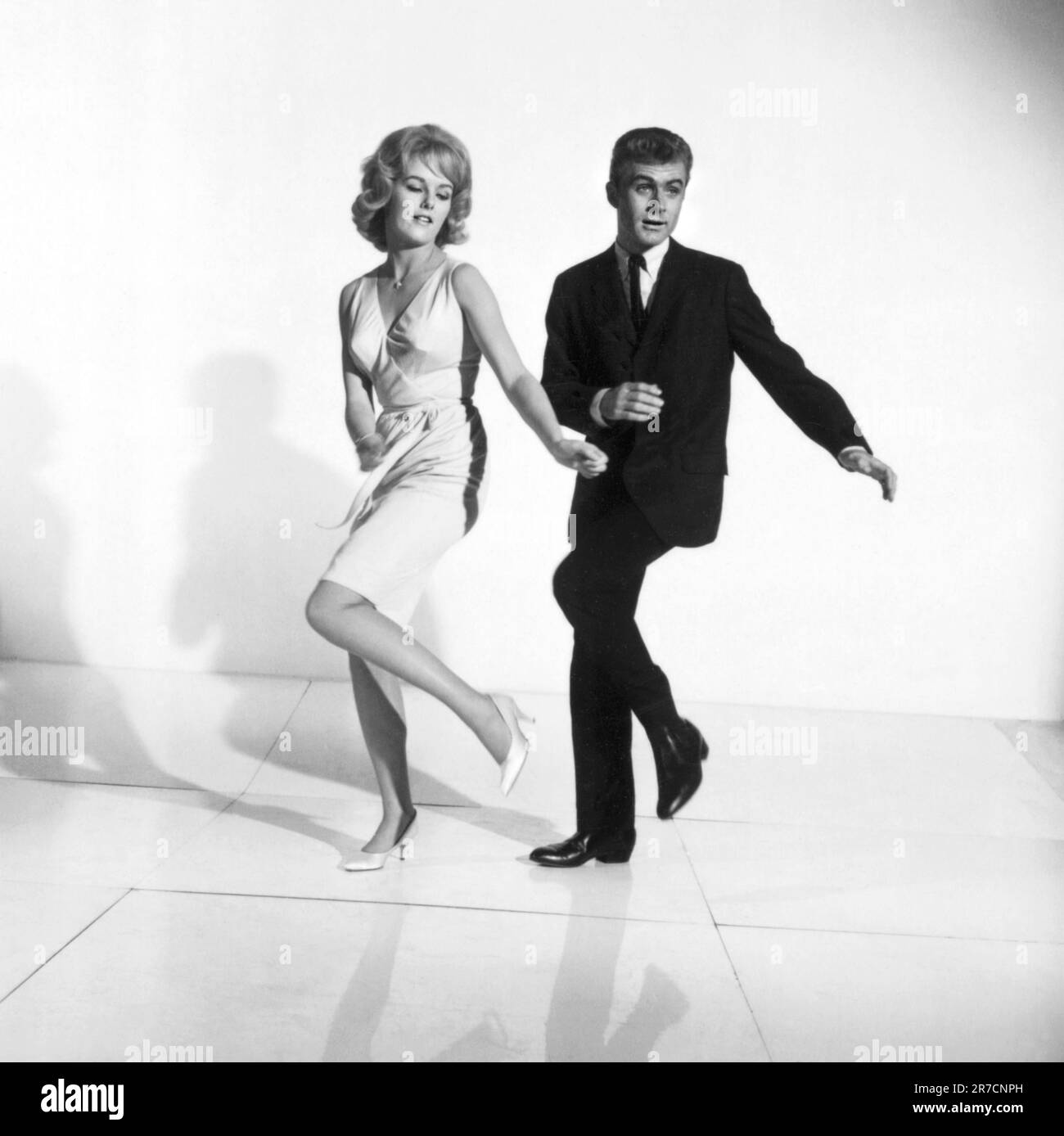 United States:  c. 1961 A photograph of a couple demonstrating how to dance the twist. Stock Photo
