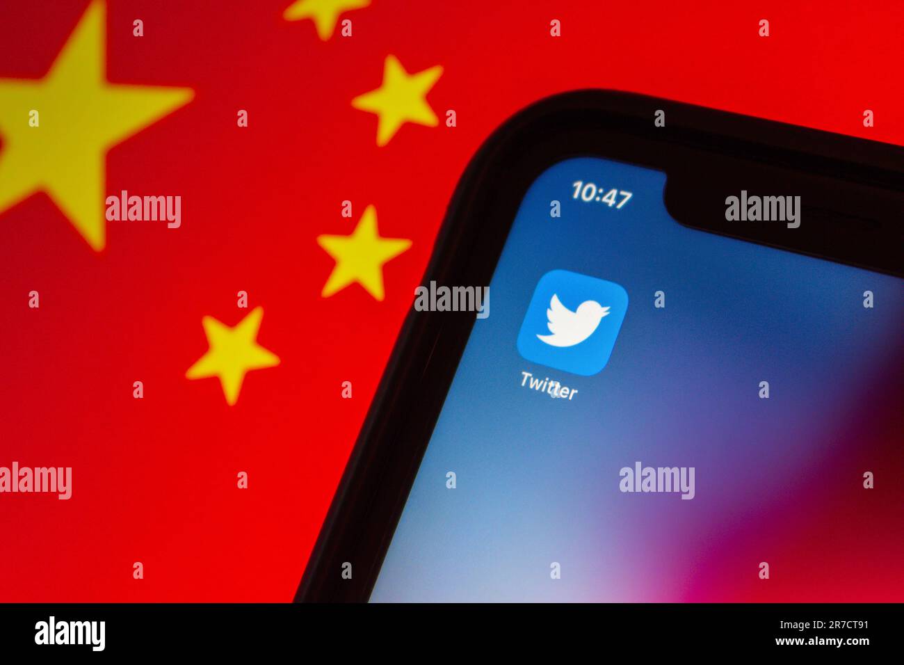 Vancouver, CANADA - Jun 14 2023 : Twitter icon seen in an iPhone on Chinese flag background. Twitter and China concept image Stock Photo