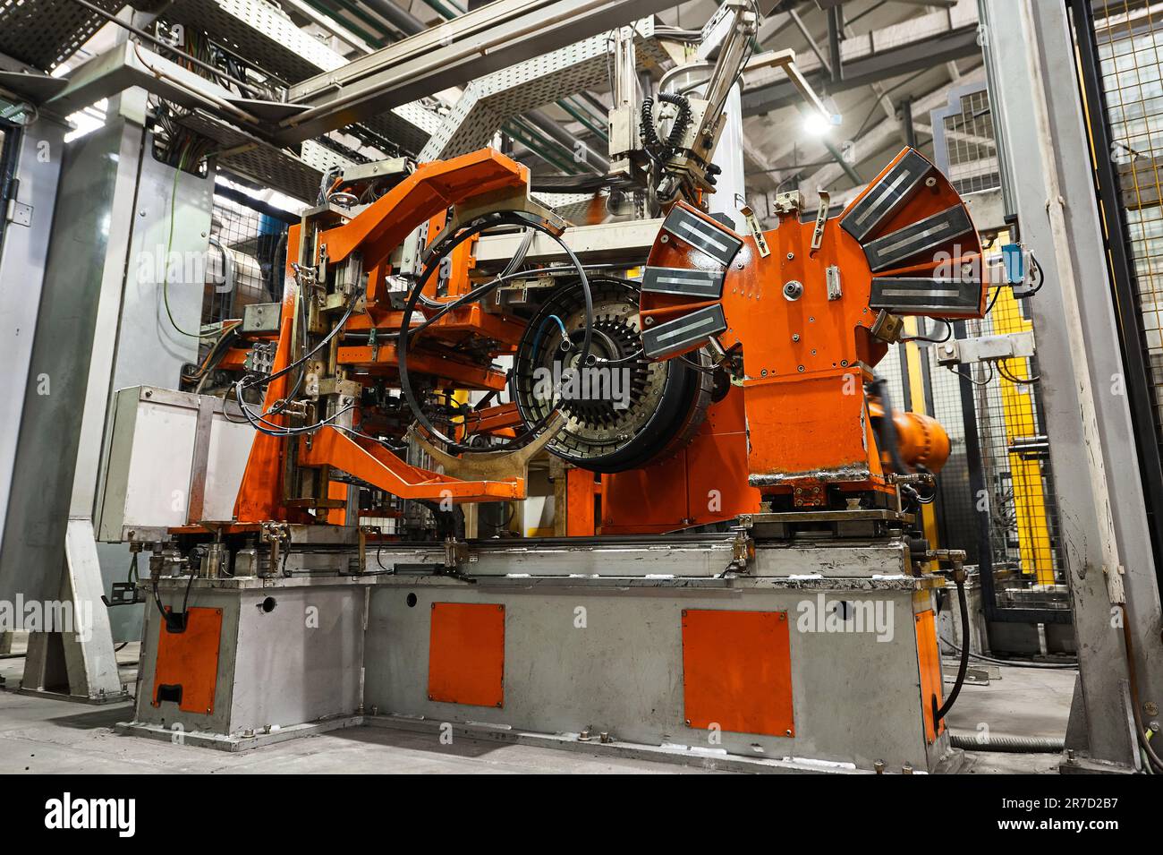 Rolling drum with rubber layers to form car tire at plant Stock Photo