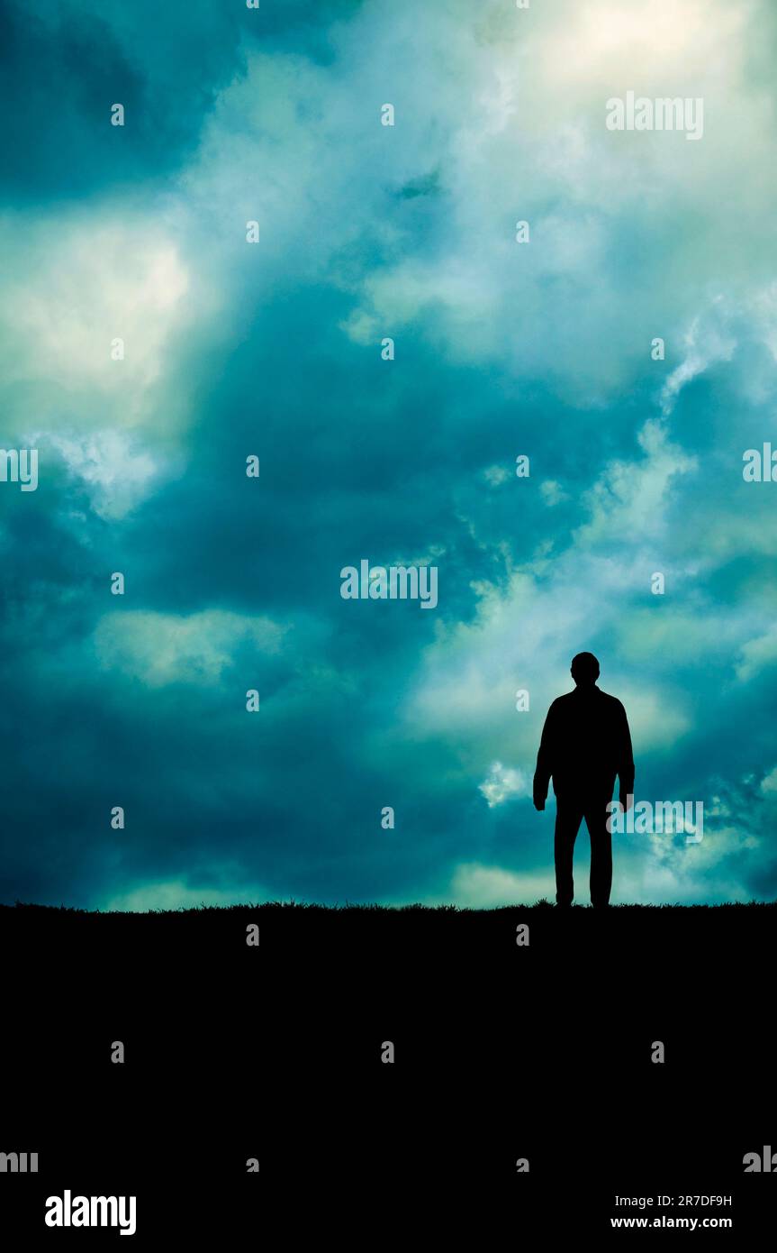 silhouette of a man standing on the edge of a cliff Stock Photo - Alamy