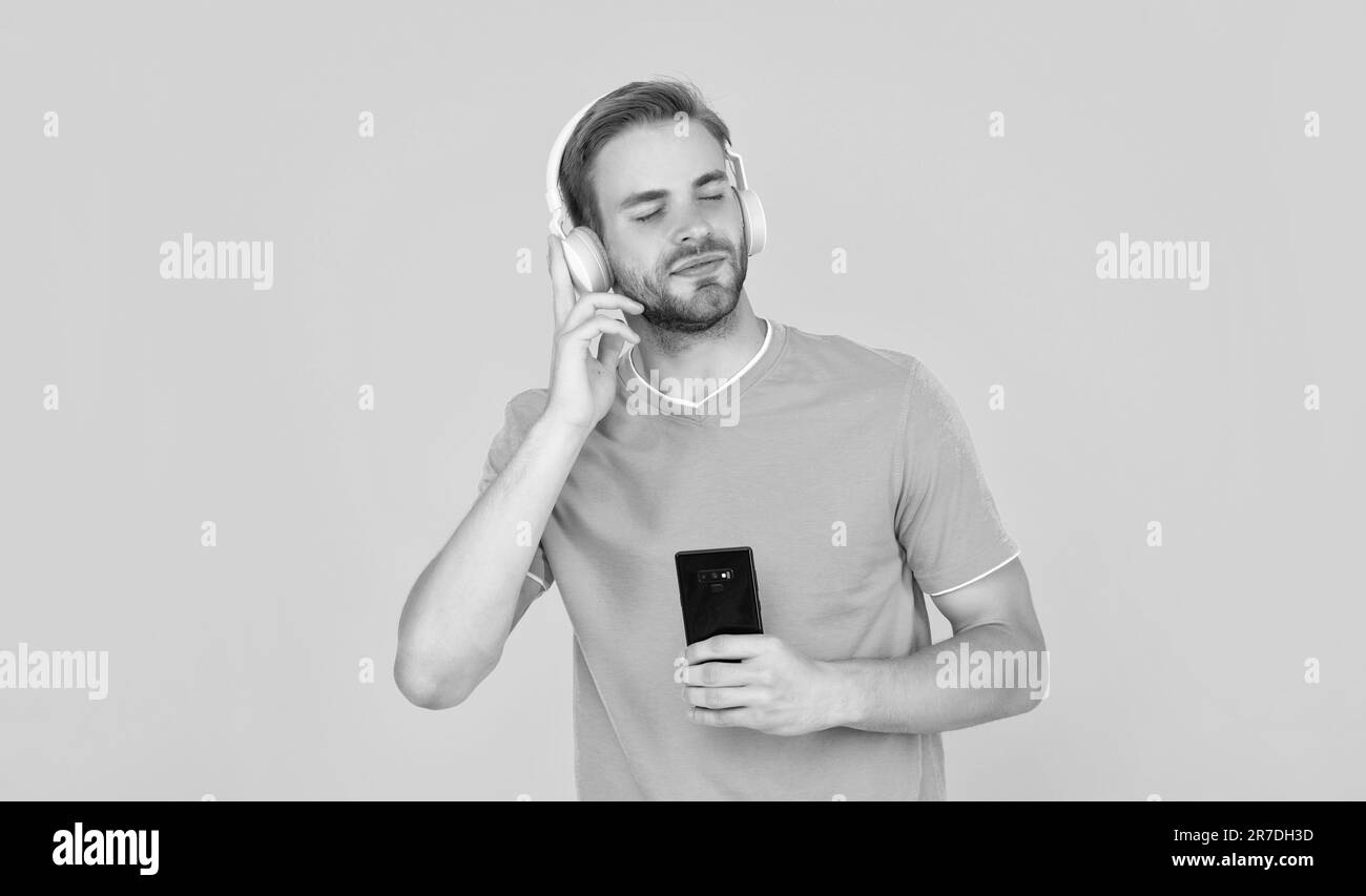Enjoy your day with positivity. Happy guy enjoy music in headphones. Lost in your own world Stock Photo