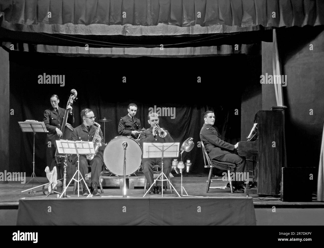 A British five-piece military dance band, the Number 2 Station Band, Farnborough onstage 5 December 1940. Farnborough, Hampshire, England, UK was home to the Royal Aircraft Establishment (RAE) and the players are wearing their RAF uniforms. Early dance and swing bands had their heyday in the UK during the 1920s–30s. Bands played in dance halls and hotel ballrooms. They played melodic, good-time music and individual players would play in several bands. This image is from an old glass negative – a vintage 1940s photograph. Stock Photo