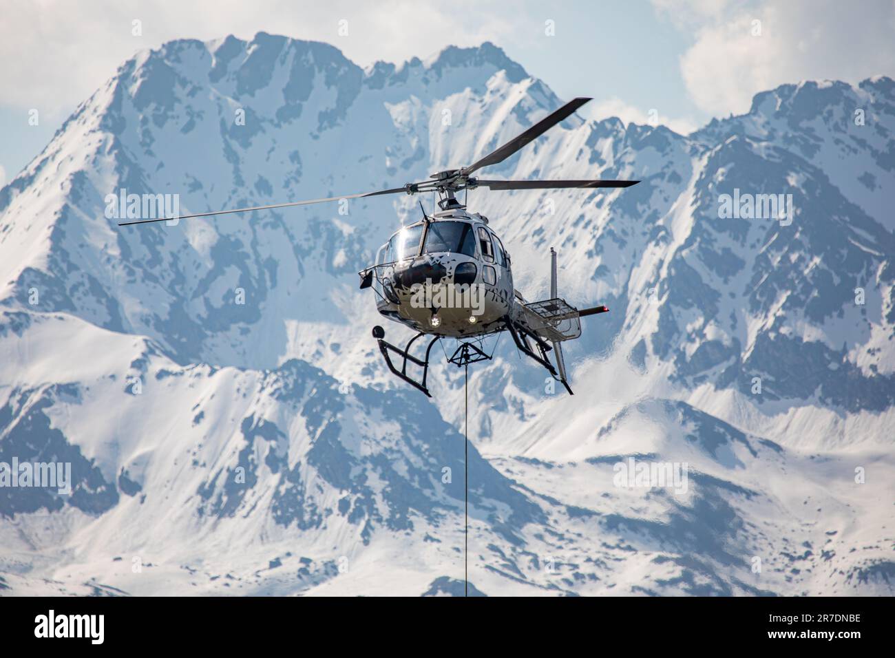 Close-up of a helicopter in the swiss mountains with rope for transport attached Stock Photo