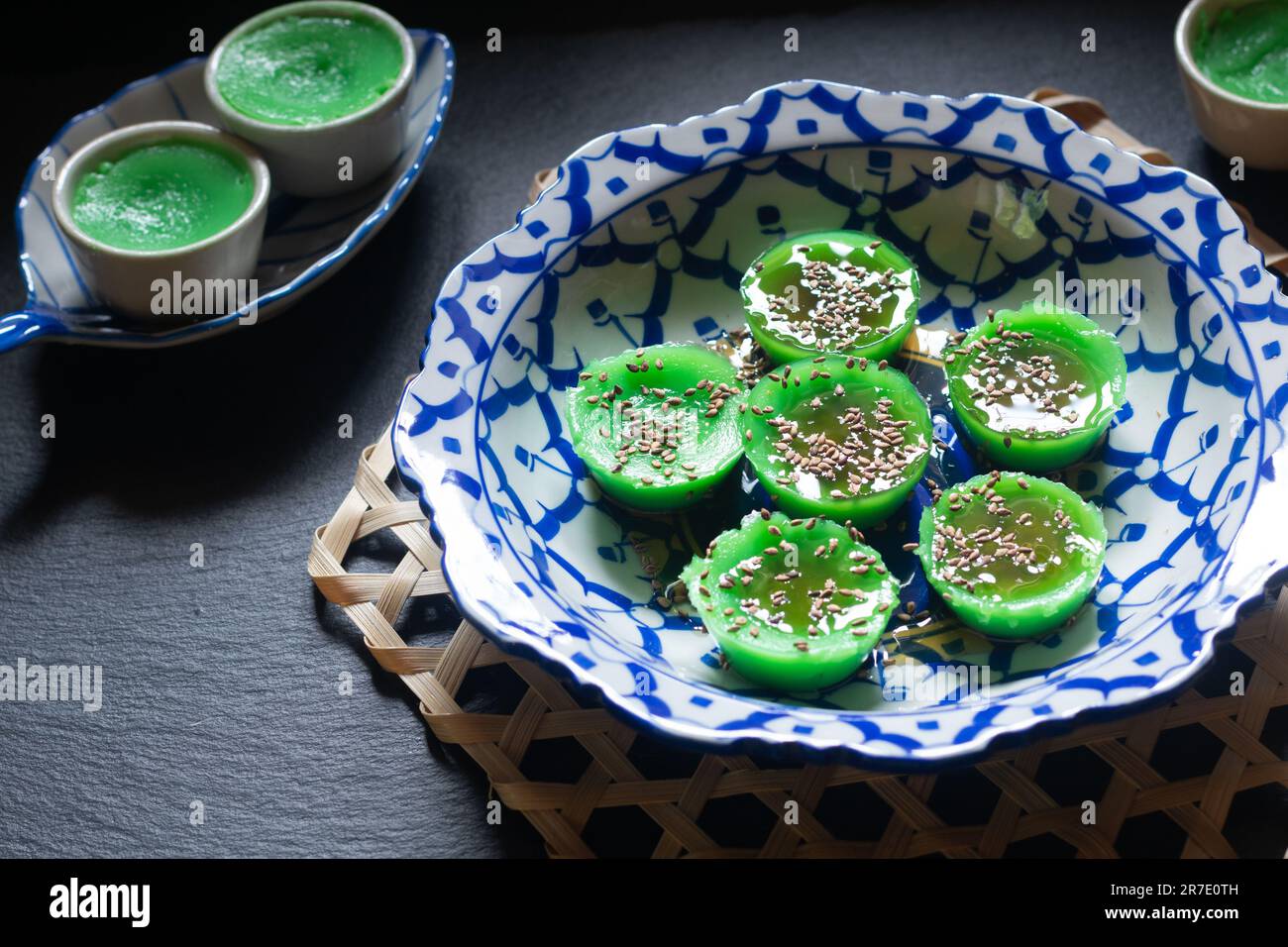 Asian food concept Thai alkaline pandan rice cake in thai pattern ceramic plate on black background with copy space Stock Photo