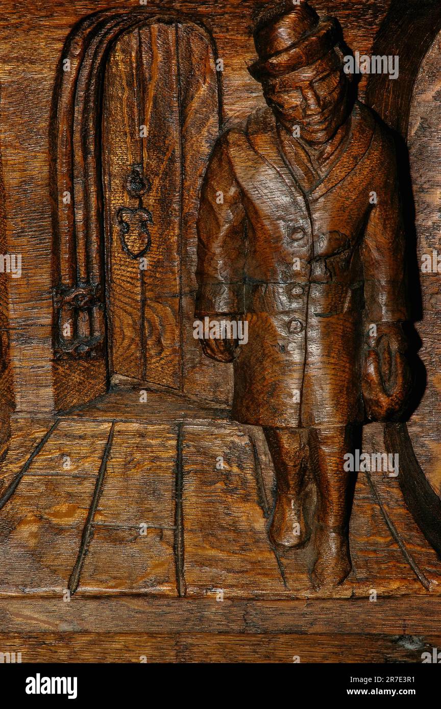 Smartly-dressed man, carved as a wooden misericord  beneath a tipping choir stall seat in the Old Church or Oude Kerk in Amsterdam, Netherlands. Stock Photo