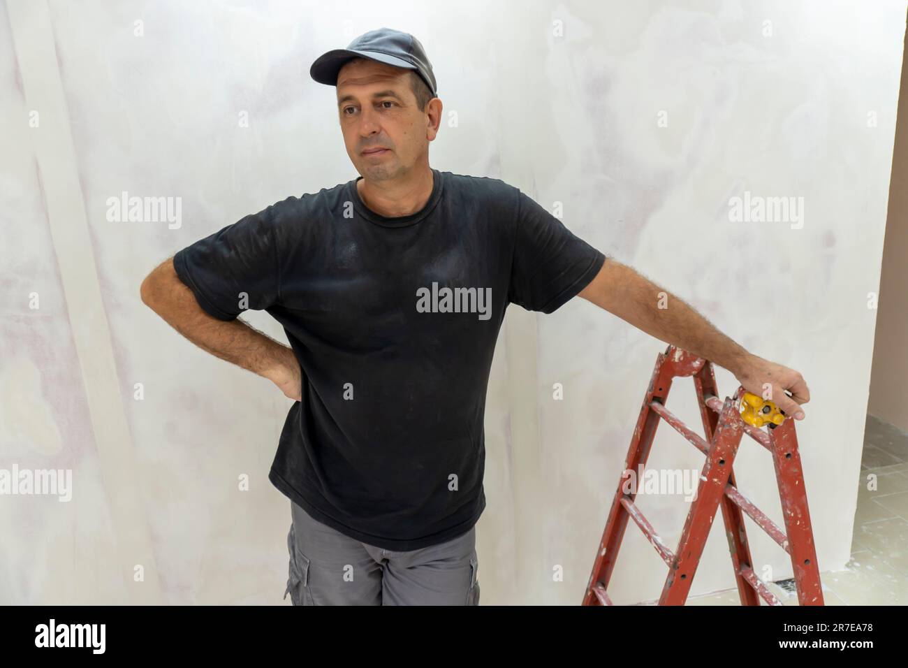 Male builder, master office, plasterer with a tool in working clothes Stock Photo