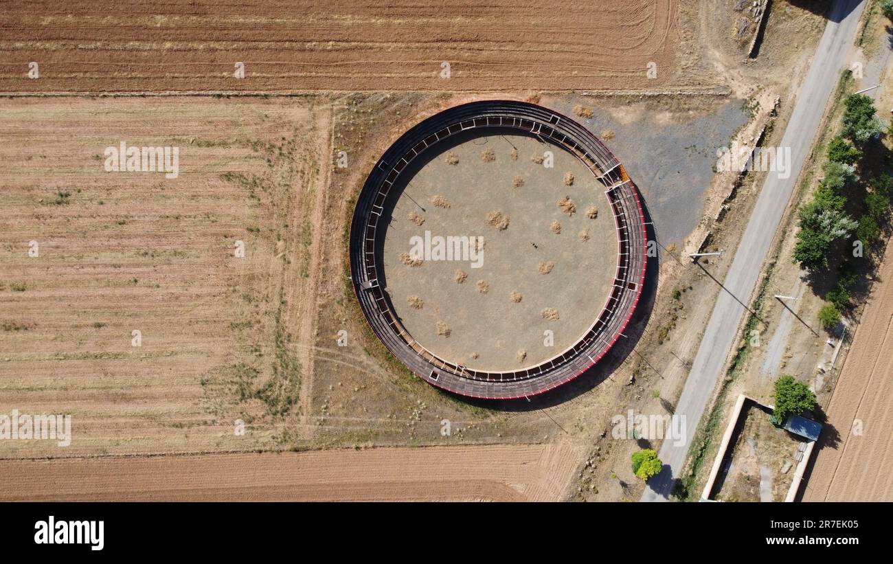 An aerial view of Plaza de Toros de Villarquemado, a circular structure located in the middle of an expansive open field Stock Photo