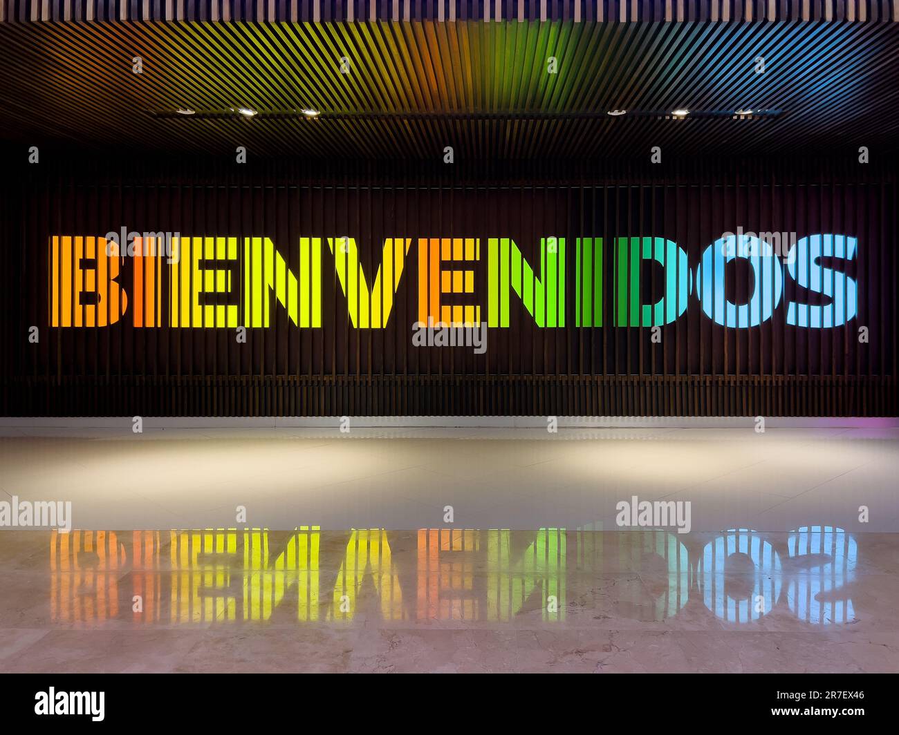A colorful Bienvenidos Welcome sign at the Cancun airport with a reflection on the floor and ceiling. Stock Photo