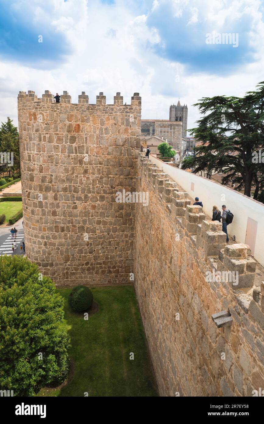 Avila wall, view in summer of people exploring the carefully preserved medieval wall that encircles the city of Avila in central Spain. Stock Photo