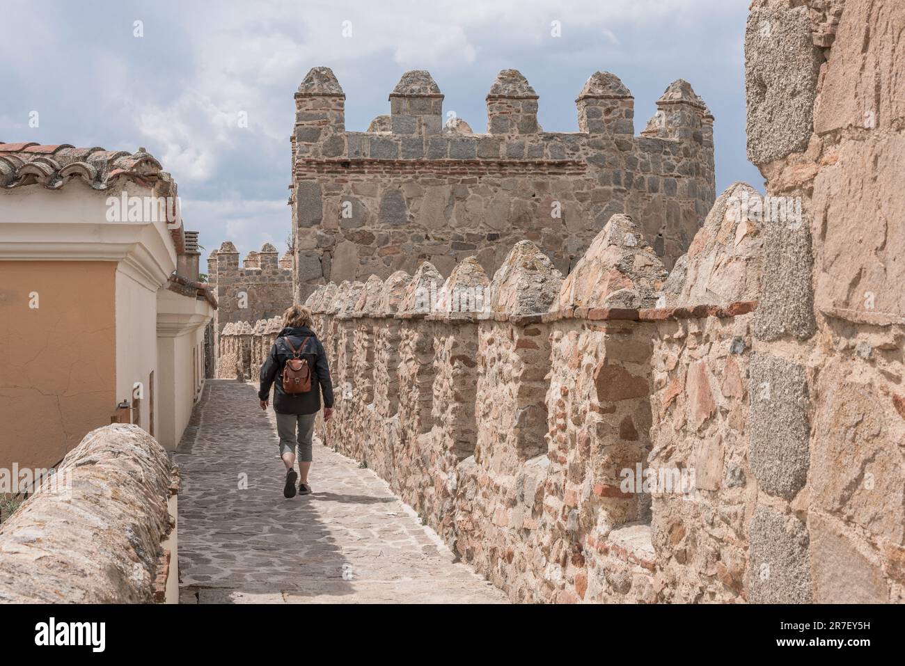 Avila wall, view in summer of a female tourist walking on the carefully preserved medieval wall that encircles the city of Avila in central Spain. Stock Photo
